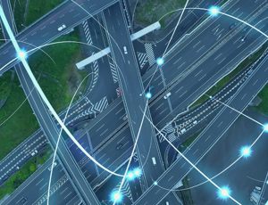 Aerial view of a motorway interchange, overlaid with glowing digital network lines