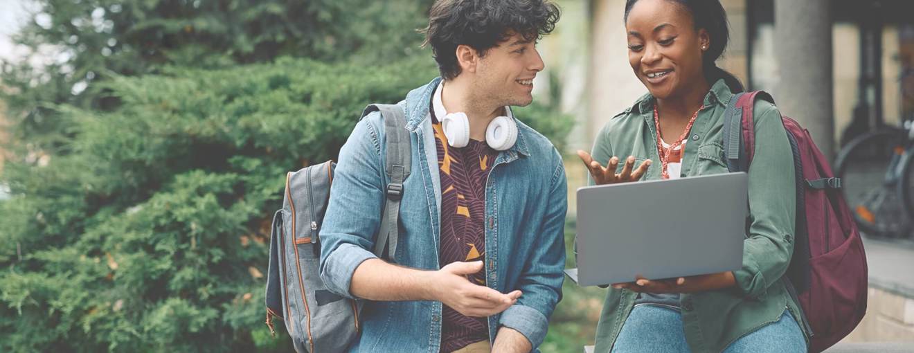 Two people smiling at a laptop